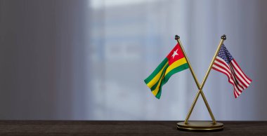 Togo ve ABD bayrakları masada. Togo ve Birleşik Devletler arasındaki müzakere. Küçük bulanık bir arkaplanda. 3B çalışma ve 3B resim