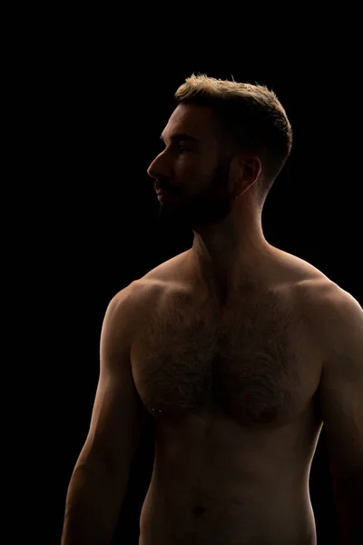 Siyah arka planda sakallı bir gencin portresi.