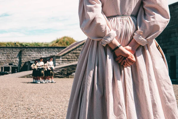 Halifax, Kanada - 22 Temmuz 2022: Arka planda orta çağ elbiseli ve silahlı bir kızın elleri yakın plan, Halifax Citadel, Kanada.