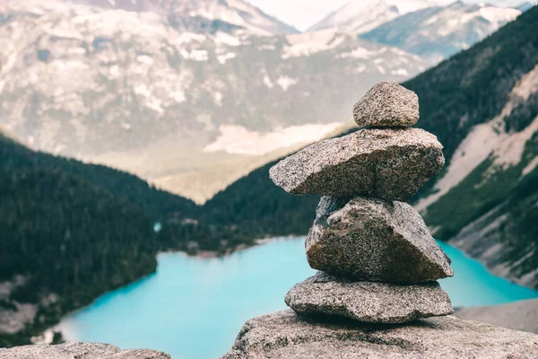 Dağlardaki bir dağ gölünün arka planında istiflenmiş taşlar.
