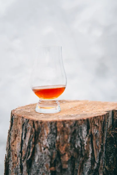Bir kış günü tahta bir kütükte bir bardak viski.