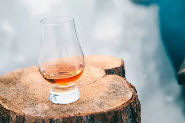Bir kış günü tahta bir kütükte bir bardak viski.