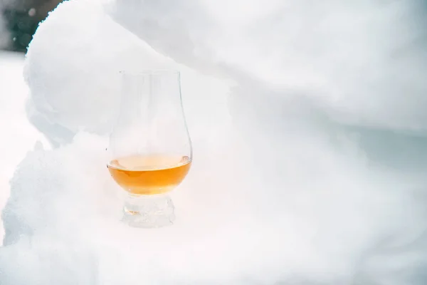 Soğuk bir kış gününde, karda bir bardak viski.