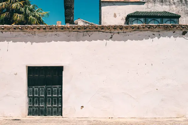 Ronda, İspanya - 23 Mayıs 2019: İspanya 'nın eski bir kasabasında siyah kapılı eski beyaz duvar