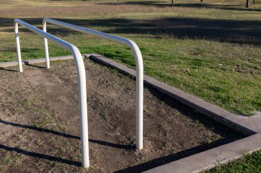 Güneybatı Phoenix, Arizona 'daki Conocido Park' ta simetrik düşük yükselen beyaz fitness çubukları.