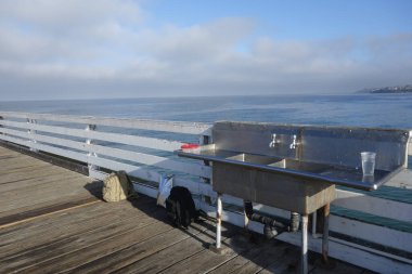 Paslanmaz çelik lavabosu olan ve Crystal Pier, Pacific Beach, San Diego, California 'da taze balık yakalamak için muslukları olan özel bir yer.