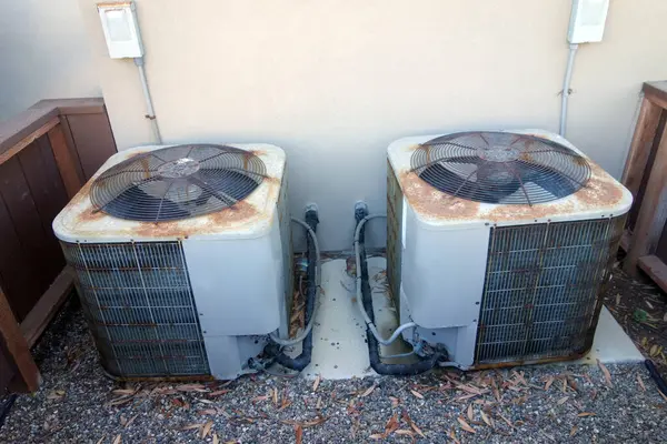 外置生锈的空调机放置在后院墙旁边 免版税图库照片