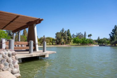 Kiwanis Park Gölü, Tempe, Arizona 'daki tekne iskelesinin üzerindeki ahşap pergola. 