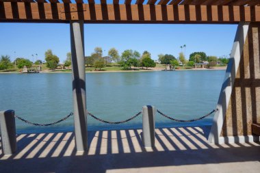 Kiwanis Park Gölü, Tempe, Arizona 'daki tekne iskelesinin üzerindeki ahşap pergola. 