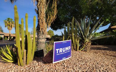 Phoenix, AZ - 27 Ekim 2024: Amerika Birleşik Devletleri Başkanlığı Aday Bahçesi tabelası kaktüslerin, agave ve diğer sulu bitkilerin arasında kral palmiyesinin altına yerleştirildi.