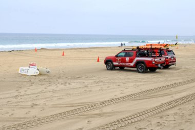 San Diego, CA - 15 Ağustos 2023: Cankurtaran ve itfaiye kırmızı renkli kamyonlar sabah San Diego, California 'da Mission Beach' te park halindeler.