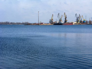 Ukrayna 'nın Zaporizhzhia kentindeki Dnipro' nun sakin suları üzerinde sol nehir kıyısındaki yük gemileri ve liman vinçleri görülüyor.