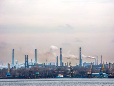 Ukrayna 'nın Zaporizhzhia kentindeki Dnipro nehrinin sol kıyısındaki korku limanında görülen fabrika borularından siyah ve beyaz duman yükseliyor.