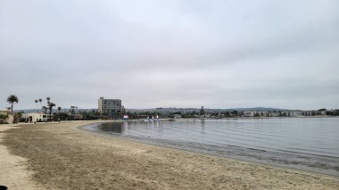 Sahil kenarındaki sayısız tatil köyü, otel ve kiralık evler Sail Bay, San Diego, California 'nın kumlu kıyısında dolup taşıyor.