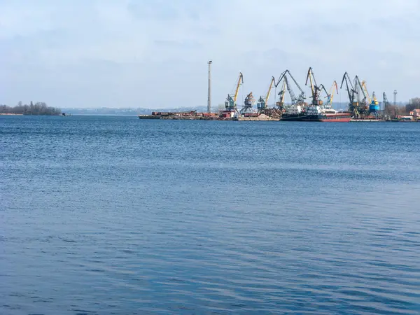 Ukrayna 'nın Zaporizhzhia kentindeki Dnipro' nun sakin suları üzerinde sol nehir kıyısındaki yük gemileri ve liman vinçleri görülüyor.