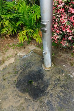 Metal borular su kolonu, basınçlı musluklar ve kumsaldaki kumdan ayakları durulamak için zemin yüzeyine yakın.