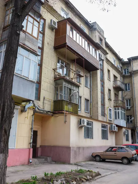 Zaporizhzhya, UA - 30 Mart 2009: Yirminci yüzyılın ortalarında Sovyet mimarisinin tipik arka bahçesi aynı zamanda Stalin binası olarak da bilinir cam kaplı balkonlar ve modern klima üniteleri yakınlardaki duvarlarda ve arabalarda park halindedir.