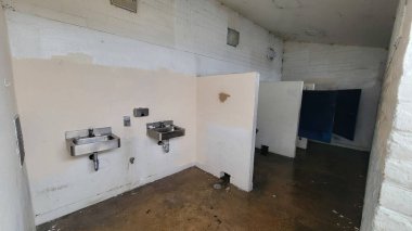 Islak zemini, paslanmaz lavabosu, kirli ışıkları, bozuk duvarları ve kilitleri olan bakımsız kapıları, Güney Pasifik Sahili, San Diego, California