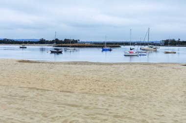 Mariners Havzası 'ndaki kumlu kumlu plaj bulutlu bir yaz sabahı San Diego, California' da demirlemiş tekne ve yatlarla dolu.