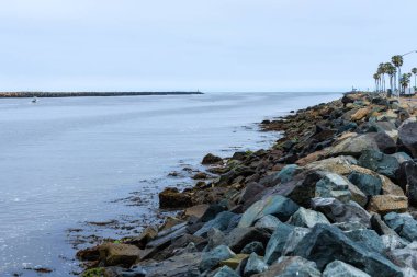 Pasifik Okyanusu çıkışına yakın Mission Körfezi Giriş Kanalı. Kaya kıyı şeridi kaba yontulmuş taşlarla kaplı, San Diego, California.