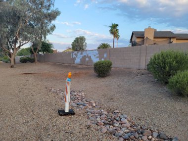 Arizona çöl stili, yol kenarı Xeriscapli beyaz boyayla işaretlenmiş bir çit.