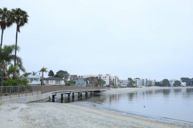 Sahil, yaya geçidi köprüsü, oteller ve tatil kiraları yaz sabahının erken saatlerinde Sail Bay 'in eğimli kıyı şeridi boyunca, San Diego, CA; kopyalama alanı