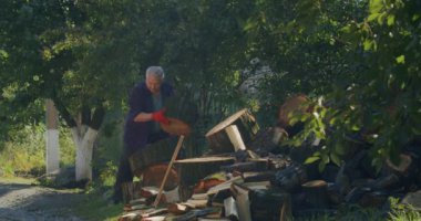 Kış için odun topluyorum. Yetişkin bir adam baltayla odun kesiyor. Ukrayna 'da kış geliyor.