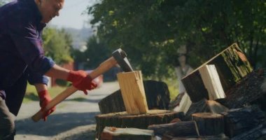 Kış için odun topluyorum. Yetişkin bir adam baltayla odun kesiyor. Ukrayna 'da kış geliyor.