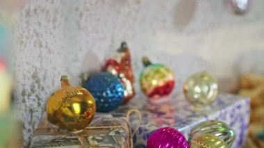 Yeni yıl gecesinde dalda asılı duran eşkenar dörtlü cam top. Noel ağacında eski oyuncaklar. Şenlikli bir gece için yakın plan dekorasyon. Arkaplanda renkli ışıklar yanıp sönüyor.