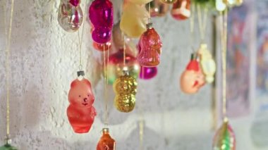 Yeni yıl gecesinde dalda asılı duran eşkenar dörtlü cam top. Noel ağacında eski oyuncaklar. Şenlikli bir gece için yakın plan dekorasyon. Arkaplanda renkli ışıklar yanıp sönüyor.
