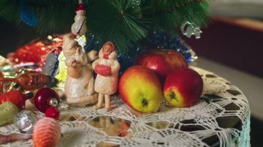 Yeni yıl gecesinde dalda asılı duran eşkenar dörtlü cam top. Noel ağacında eski oyuncaklar. Şenlikli bir gece için yakın plan dekorasyon. Arkaplanda renkli ışıklar yanıp sönüyor.