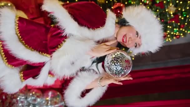 快乐的女人桑塔夫人在圣诞树下的一个水晶镜像球中欢欣鼓舞 良好的新年精神 — 图库视频影像