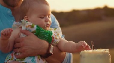 Childs 'ın yaşam tarzı. Sonbahar tarlasında mutlu yıllar. Gün batımında küçük çocuk, çadırda pastayla. Fotoğrafçı doğum günü fotoğrafı çekiyor. Aile ve bebek sevinci