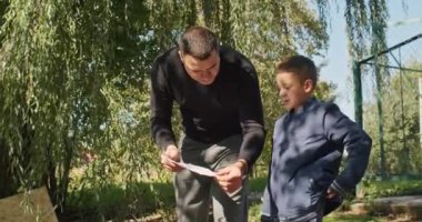 Mutlu baba ve oğul ağaçta bir ev inşa eder, bir çizime bakar, bir ağacı testereyle keser, tornavidayla kendi kendini becerir..