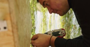 Mutlu baba ve oğul ağaçta bir ev inşa eder, bir çizime bakar, bir ağacı testereyle keser, tornavidayla kendi kendini becerir..