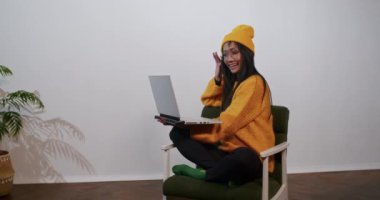 neşeli Asyalı kadın iş ve video iletişimi için dizüstü bilgisayar ve telefon kullanıyor