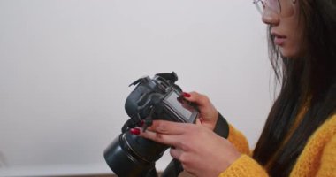 Asyalı kadın beyaz arkaplanda fotoğraf seçiyor..