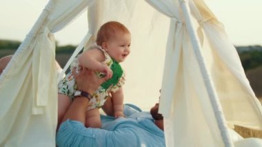 Childs 'ın yaşam tarzı. Sonbahar tarlasında mutlu yıllar. Gün batımında küçük çocuk, çadırda pastayla. Fotoğrafçı doğum günü fotoğrafı çekiyor. Aile ve bebek sevinci