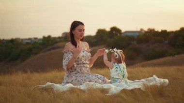 Childs 'ın yaşam tarzı. Sonbahar tarlasında mutlu yıllar. Gün batımında küçük çocuk, çadırda pastayla. Fotoğrafçı doğum günü fotoğrafı çekiyor. Aile ve bebek sevinci