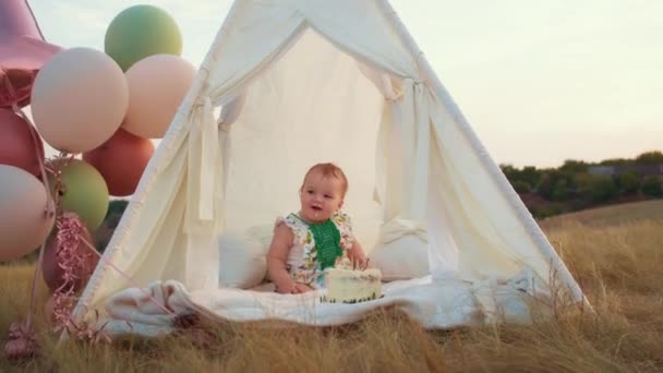 子供のライフスタイル ケーキとテントの中の日没の小さな子供の秋のフィールドで幸せな誕生日 写真家が誕生日を撮る 家族と赤ちゃんの喜び — ストック動画