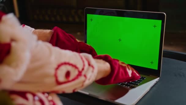 Święty Mikołaj Siedzi Koło Choinki Trzymając Laptopa Zielonym Ekranem Zwracając — Wideo stockowe