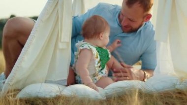 Childs 'ın yaşam tarzı. Sonbahar tarlasında mutlu yıllar. Gün batımında küçük çocuk, çadırda pastayla. Fotoğrafçı doğum günü fotoğrafı çekiyor. Aile ve bebek sevinci