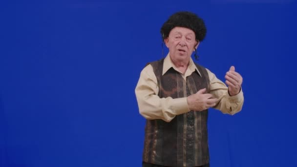 蓝色屏幕上的一位犹太老人祝你快乐 哈沙纳 一位身穿民族服装的老犹太人的新年祝福 — 图库视频影像