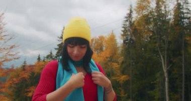 Genç bayan gezgin dağlarda serin sonbahar havasının tadını çıkarıyor ve eğleniyor. Sonbahar soğuk havası. Z kuşağı yolculuğu.