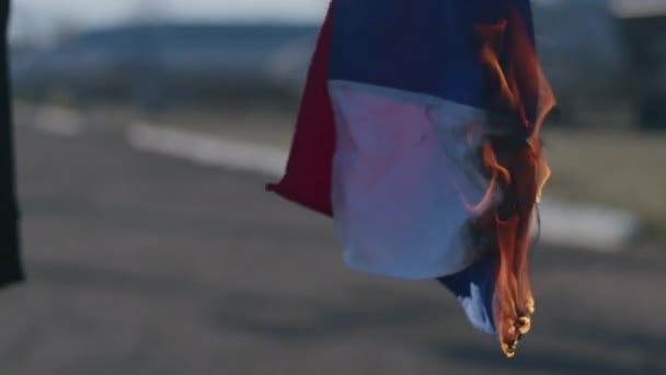 乌克兰和俄罗斯之间的冲突 一个人的手拿着一面燃烧的俄罗斯国旗 战争2022年 — 图库视频影像