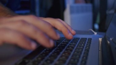 Yakın plan, erkek bir video editörünün elleri stüdyodaki bir dizüstü bilgisayarda işlem görüyor.