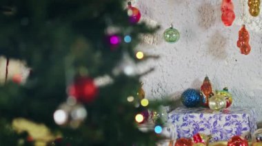 Yeni yıl gecesinde dalda asılı duran eşkenar dörtlü cam top. Noel ağacında eski oyuncaklar. Şenlikli bir gece için yakın plan dekorasyon. Arkaplanda renkli ışıklar yanıp sönüyor.