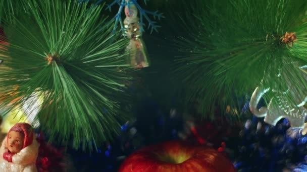 新年の夜に枝に吊るされた菱形のガラス玉 クリスマスツリー上のヴィンテージのおもちゃ お祝いの夜のためのクローズアップ装飾 背景には色灯がちらつき — ストック動画