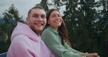 Genç bir çiftin dağlarında tatil, kayak asansörüne tırmanırlar, manzaranın tadını çıkarırlar, duygularını gösterirler..