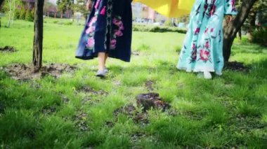 Ukrayna bayrağıyla çiçek açan pembe sakura çiçeklerinin arka planına sevinen iki mutlu kadın. Hafta sonu yürüyüşü, gün batımında bir gülümsemeyle. Kadın ve bahar